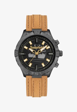 Orologio Timberland con quadrante nero, finiture dorate e grandi indici delle ore. Presenta una cassa nera e un cinturino in pelle marrone chiaro con cuciture.