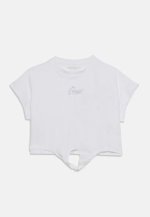 Λευκό κοντομάνικο T-shirt crop με μικρό λογότυπο "Guess" από στρας στο στήθος και κόμπο στο τελείωμα μπροστά.