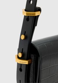 Schwarzer Leder-Handtaschengurt mit strukturierter Oberfläche, akzentuiert durch goldene Beschläge und den eingravierten Markennamen "ALLSAINTS".