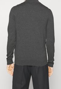 Maglione grigio scuro a maniche lunghe in un tessuto fine con colletto tondo, con polsini e orlo a coste, mostrato da dietro.