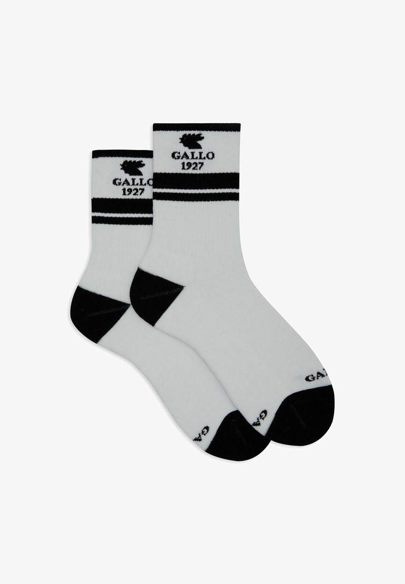 Ein Paar weiße Crew-Socken mit schwarzer Ferse, Spitze und Streifen, die den Text "Gallo 1927" und ein Hahnl logo nahe dem oberen Rand zeigen.