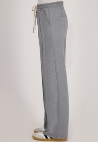 Grijze sweatpants met een elastische tailleband en witte trekkoord. Voorzien van zijzakken en een recht model. Zacht, lichtgewicht stof.