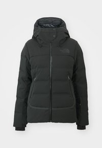 Giacca invernale nera imbottita con cappuccio, chiusura frontale a zip, due tasche laterali con zip e logo sul lato sinistro del petto.