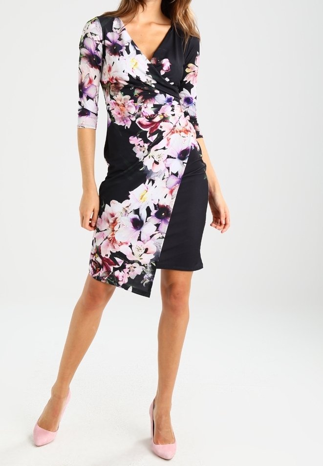 Svart klänning med trekvartslånga ärmar som har ett blommönster i nyanser av rosa och lila över framsidan; slätt tyg; knälång.