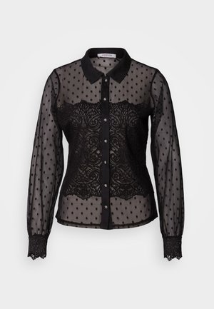 Blusa negra transparente con lunares y detalles de encaje, diseño con cuello, mangas largas, cierre de botones y puños con ribete de encaje.