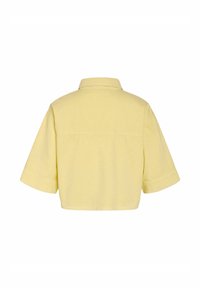 Chemise jaune clair à manches courtes, coupe large, ourlet droit et empiècement dos sous un col classique.