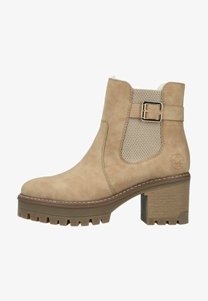 Beige ankelstøvle med en robust blokhælhæl, tekstureret beige sidestykke og metalspænde. Har en glat ruskindsfinish og en hårdfør sål.