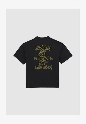 Musta lyhythihainen T-paita, jossa on keltainen sarjakuvakuva aaltoa tervehtivästä merimiehestä. Takana tekstit "DICKIES", "29", "22" ja "LAND AHOY!".