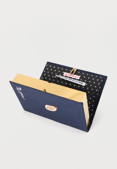 Τσαντάκι σε ναυτικό μπλε με εσωτερικό επενδυμένο με σχέδιο χρυσά άστρα, μπεζ φόδρα, χρυσό κούμπωμα και ετικέτα που γράφει «Χειροποίητο με αγάπη στην Ιταλία».