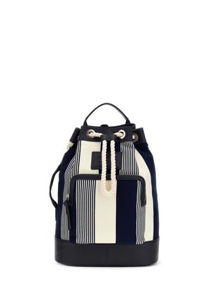 Sac à dos rayé bleu marine et blanc avec base en cuir noir, poche avant zippée et fermeture à cordon blanc.