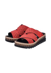 Sandales rouges avec un design à lanières croisées, fabriquées en matériau texturé. Présentent une semelle intermédiaire en jute tissé et une semelle extérieure en caoutchouc noir.