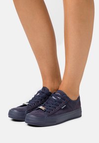 Baskets bleu marine avec une tige en suède lisse, un design à lacets et une semelle en caoutchouc texturée. Présentent un accent de logo sur la languette et le côté.