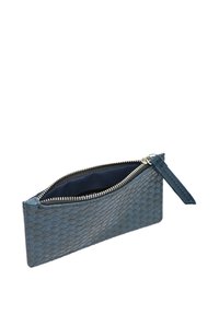 Tkanjena usnjena torbica temno modre barve z gladko teksturo. Opremljena je s srebrnim zadrgo in usnjeno zanko, delno odprta, da razkrije mornarsko notranjost.