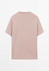 T-shirt a maniche corte, con collo rotondo, in morbido tessuto rosa. Presenta un colore uniforme senza fantasie, mostrando una texture semplice e liscia.