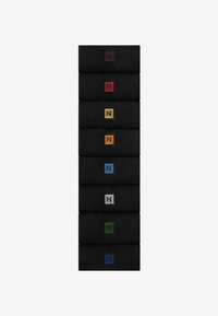 Stack of black socks featuring embroidered "N" logos in various colors: dark red, orange, yellow, blue, green, gray, and light blue accents.