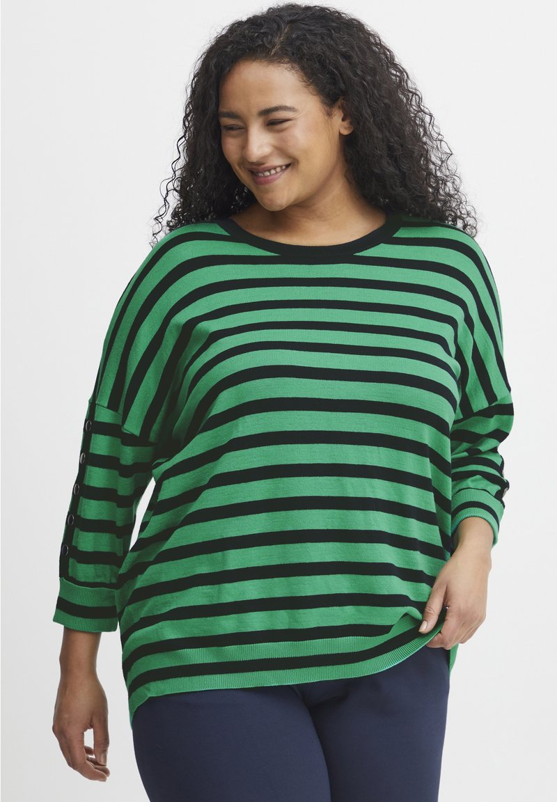 Zeleno-črno črtasta jopica s prostim krojem, okroglim izrezom in gumbnimi detajli na rokavih. Mehka pletenina s sproščenim oblikovanjem.