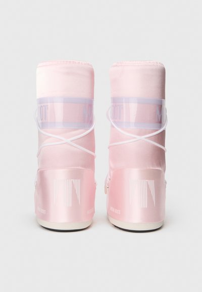 Botas de luna rosas con acabado satinado, correas translúcidas y acentos blancos. Presentan una textura suave y una suela de goma negra.