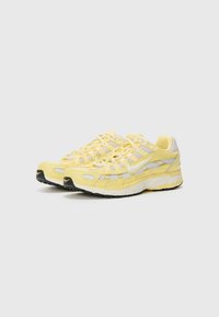 Lichtgele sneakers met een bovenwerk van mesh, reflecterende accenten en een zwarte rubberen zool. Heeft een dikke zool en een vetersluiting.
