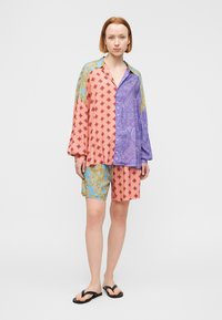 Πολύχρωμο πουκάμισο με μίξη σχεδίων σε ροζ, μοβ και μπλε χρώματα· συνδυασμένο με σορτς στο ίδιο χρώμα. Μαλακό ύφασμα, σχεδίαση με κουμπιά, άνετη εφαρμογή.