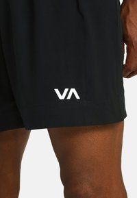 Zwarte sportshorts met een wit "VA" logo, gemaakt van lichtgewicht materiaal met een gladde textuur en een perfect passende snit.