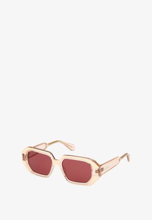 Lunettes de soleil avec des verres octogonaux teintés de rose. Monture claire et brillante avec des accents dorés et des branches fines. Design léger, esthétique moderne.