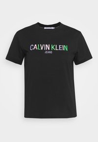 Černé bavlněné tričko s vícebarevným vyšitým textem "CALVIN KLEIN JEANS" na přední straně, kulatým výstřihem a krátkými rukávy.
