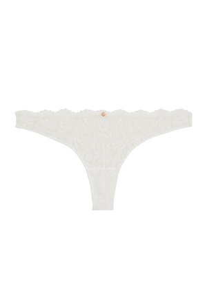Tanga pour femmes en dentelle blanche avec motif floral et petite breloque ronde dorée au centre de la taille.