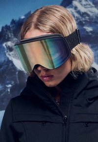 Smučarska očala z veliko zrcalno lečo, ki se preliva iz zelene v vijolično, s črnim teksturiranim trakom in elegantnim, nizkim profilom.