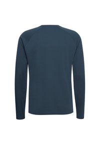 Ciemnoniebieska, teksturowana koszula z długim rękawem i szwami raglanowymi, pokazana od tyłu na białym tle.