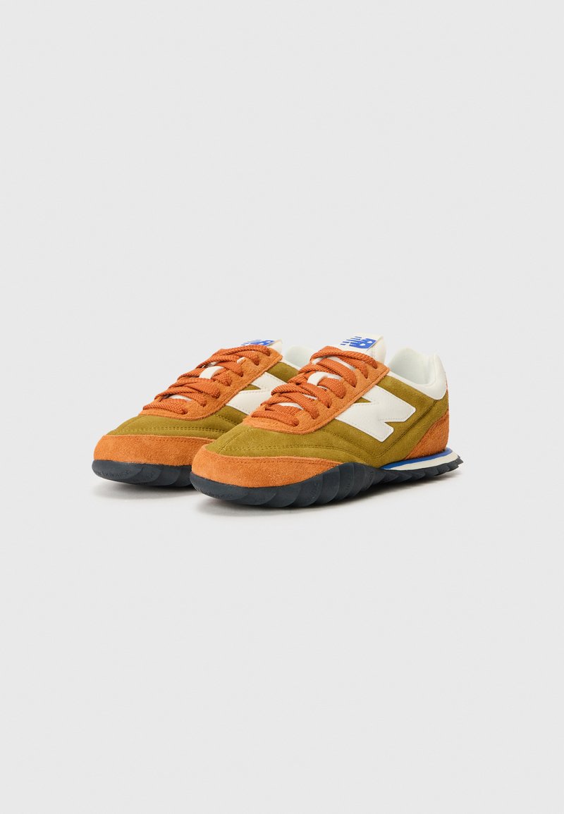 Zapatillas con una mezcla de ante naranja y verde oliva, acentos blancos, logotipo azul y una suela de goma negra con un patrón texturizado.
