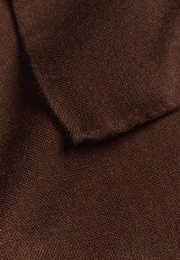 Tifă brună cu un țesut texturat, arătând o suprafață moale și margini pliate. Materialul pare durabil, având o textură aspră, dar netedă.