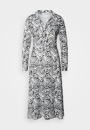 Fekete-fehér mintás ruha, gallérral, hosszú ujjakkal, gombos részletekkel és laza fazonnal, melyen hullámos csíkok futnak végig.