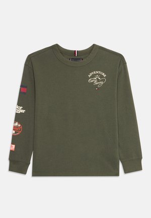 Dunkelgrünes Langarmshirt mit dem Aufdruck "Abenteuer im Camp Tommy" und kleinen Logos auf der Brust und dem Ärmel, Rundhalsausschnitt, aus Baumwollstoff.