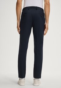 Marineblaue Hose mit geradem Schnitt, ausgestattet mit zwei Gesäßtaschen mit Knöpfen, aus einem glatten, leichten Stoff gefertigt.