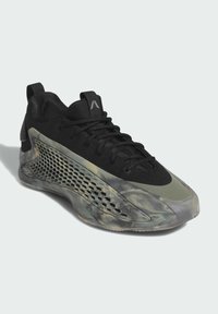 Scarpa sportiva nera con tomaia texturizzata, suola traslucida marmorizzata e un caratteristico motivo a nido d'ape sul lato per la ventilazione.