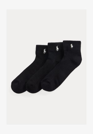 Trois chaussettes noires à la cheville avec bords côtelés, chacune présentant un petit logo brodé blanc de joueur de polo près du haut.
