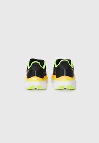Zapatillas deportivas negras con un upper texturizado, acentos en verde neón, entresuela naranja y suela blanca. Cuentan con un collar y talón acolchados.