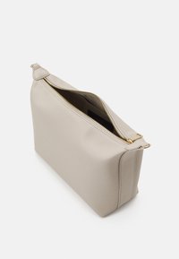Beige leather handbag with a rectangular shape, gold zipper, and smooth texture. Features a top opening and stitched detailing along edges.