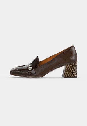 Zapato de cuero marrón oscuro con tacón bajo, puntera cuadrada, correa decorativa y botón metálico redondo, tacón bloque con estampado sobre fondo blanco.