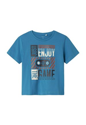 Camiseta de algodón azul con manga corta, que presenta una impresión gráfica en varios colores con el texto "SIMPLEMENTE DISFRUTA DEL JUEGO" con un motivo de controlador de juego.