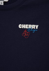 Tissu bleu marine avec le texte blanc "CHERRY" et le texte bleu "Days", accompagné d'un contour rouge de trois cerises sous le mot "CHERRY".