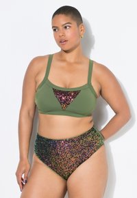 Top de bikini verde con un acento triangular de lentejuelas. Parte inferior de tiro alto en lentejuelas multicolores, con un degradado de verde a púrpura.