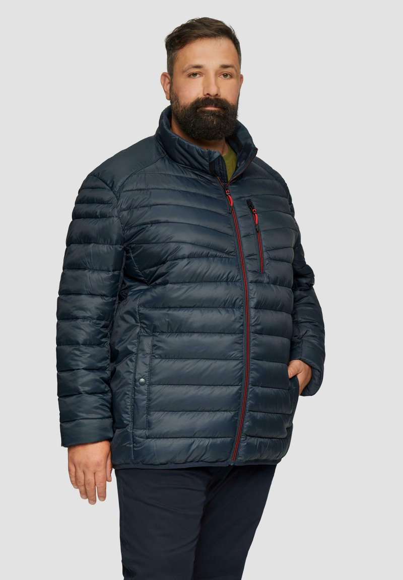 Marineblauer Puffer-Jacke mit gestepptem Design, vollständigem Reißverschluss und roten Akzenten, Stehkragen und Seitentaschen. Entwickelt für Wärme und Komfort.