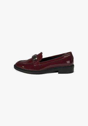 Mocassin en cuir verni bordeaux avec semelle noire, talon bas et détail de boucle en métal argenté sur la bride.