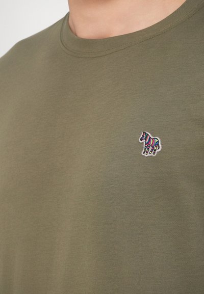 Πράσινο ελιάς βαμβακερό μπλουζάκι με μικρή πολύχρωμη κεντητή λεπτομέρεια αλόγου στο αριστερό στήθος. Λαιμόκοψη τύπου λαιμός και ομαλή υφή.