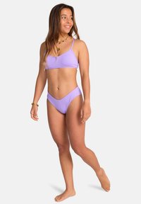 Purple bikini set featuring a simple design, adjustable straps, and a V-shaped bottom. Smooth texture with minimal hardware accents.