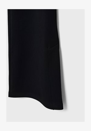 Schwarze Sportpants mit glatter Textur, abgerundetem Saum, Seitentasche und kontrastierenden Nähten, die für Komfort und Bewegungsfreiheit entwickelt wurden.