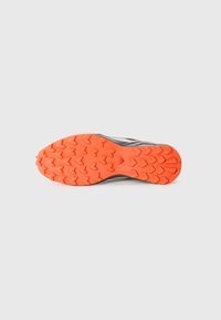 Black and gray running shoe sole with a textured orange rubber outsole featuring a heart pattern. Designed for traction and stability.