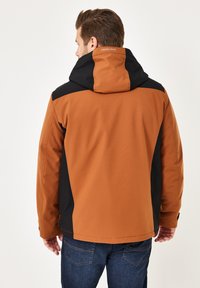 Braune und schwarze Kapuzenjacke mit einer glatten Textur, die ein Design in kontrastierenden Farben aufweist, verstellbare Ärmelbündchen hat und ein Logodetail auf dem Rücken zeigt.
