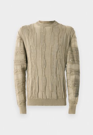 Beige sweater with textured ridges and distressed details, featuring a round neckline and ribbed cuffs and hem. Knit fabric.
